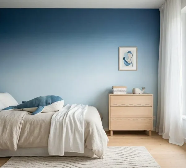 Chambre d'enfant avec thème marin aux tons bleus apaisants, mur bleu dégradé, et objets marins décoratifs