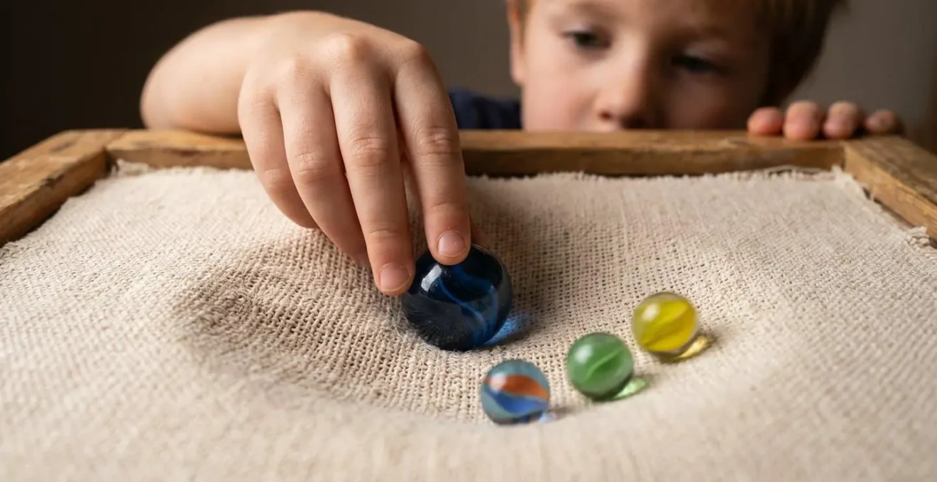 Enfant réalisant une expérience de simulation de trou noir avec un tissu tendu et une bille