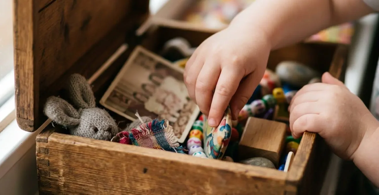 Enfant de 3 ans ouvrant avec curiosité une boîte colorée remplie de petits présents